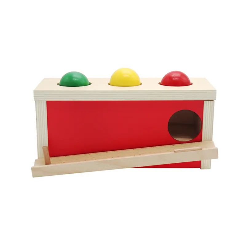Eine Montessori-Kiste zur Hand-Augen-Koordination mit drei Bällen im Inneren.