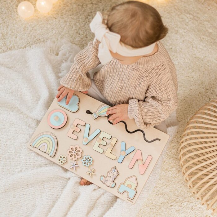 A little girl plays happily with a Personalized First Name - Wooden Puzzle bearing her own name, "Evelyn.