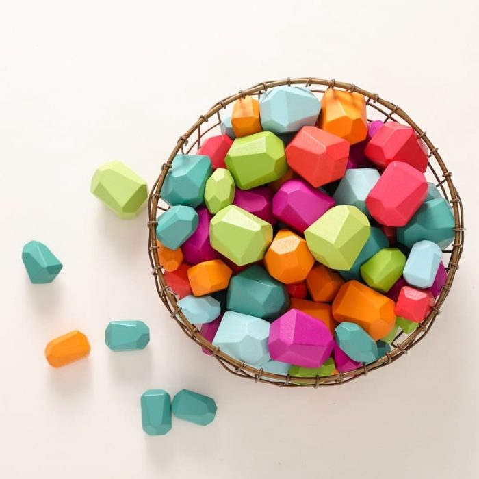 A basket filled with Wooden Building Blocks in the Shape of Colored Stones.