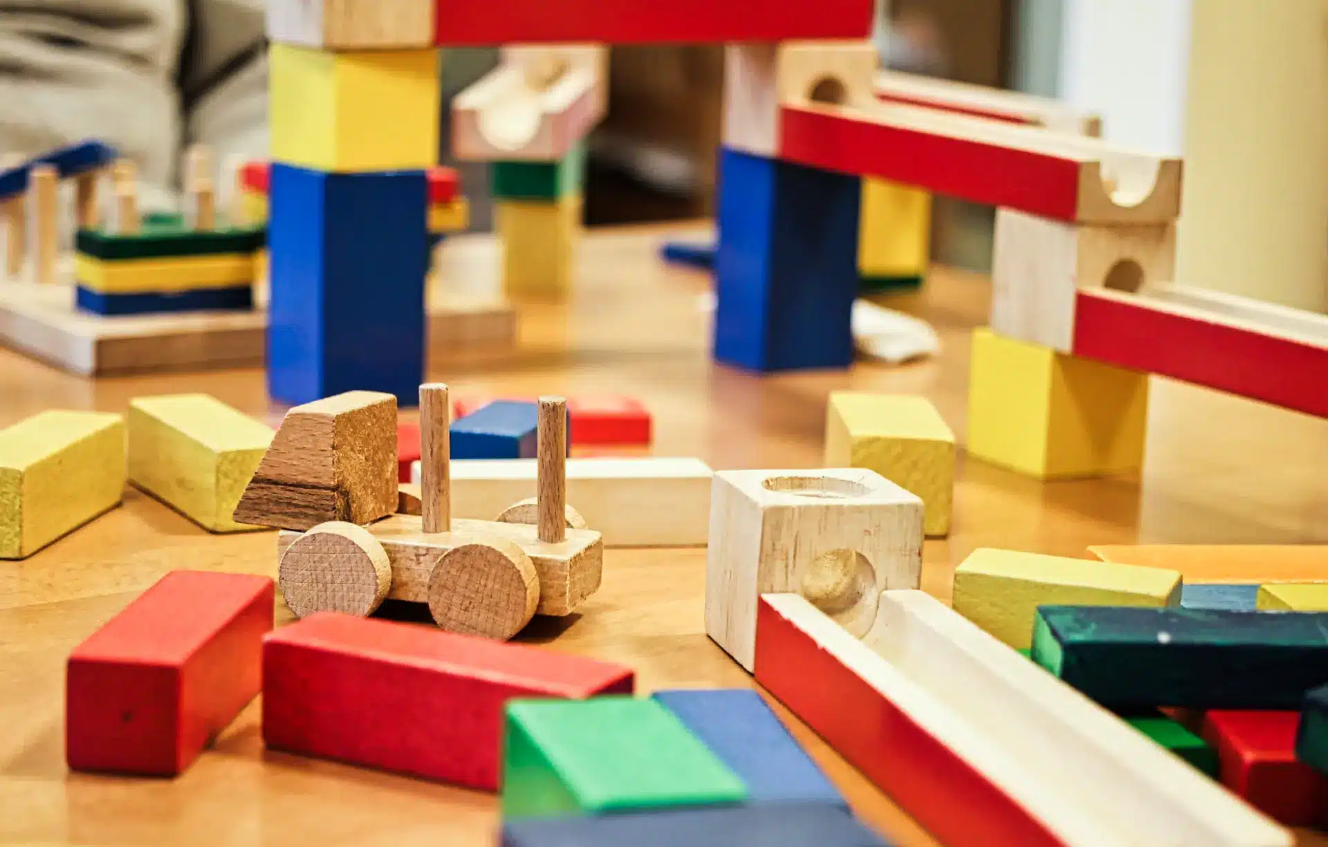 Un enfant participe à diverses activités d'inspiration Montessori, notamment jouer avec des blocs de bois.