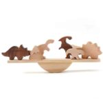 Eine Reihe von Holzspielzeug von Balancierspiele Tiere und Dinosaurier aus Holz auf einer Holzplattform.