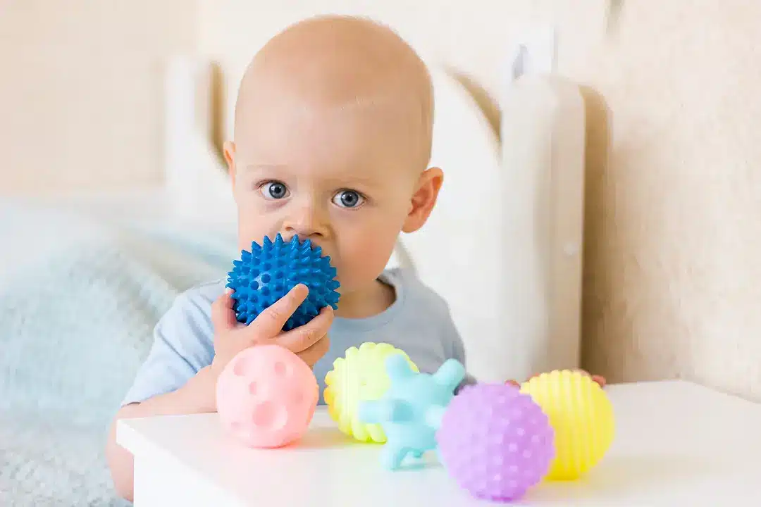 Montessori c'est quoi ? Enfant avec des balles sensorielles