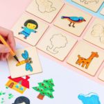 Ein Kind benutzt Montessori Holzschablonen für Kinder - 20 Stück, um Bilder auf einem Holzbrett zu gestalten.