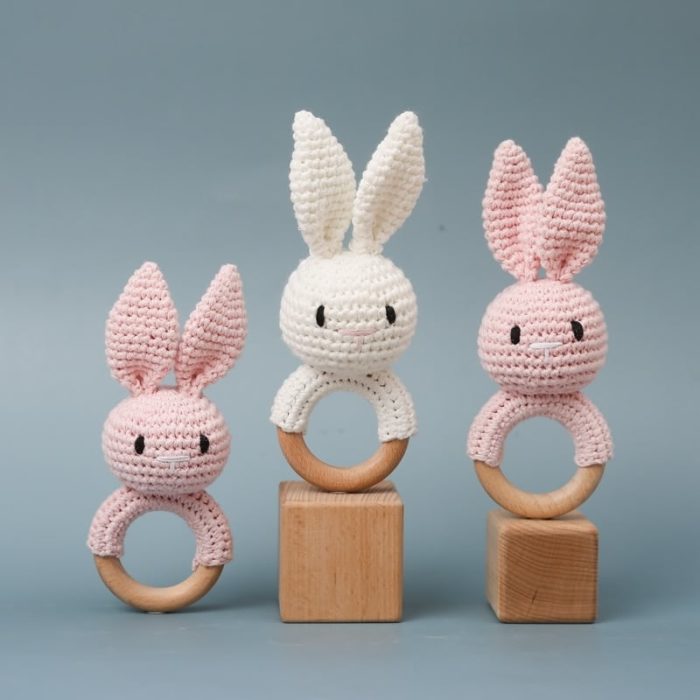 Three knitted rabbit wooden rattle toys.