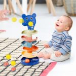 Ein Baby spielt mit einem farbenfrohen Spielzeugturm Rollender Ballturm 7 Etagen - 45 cm.