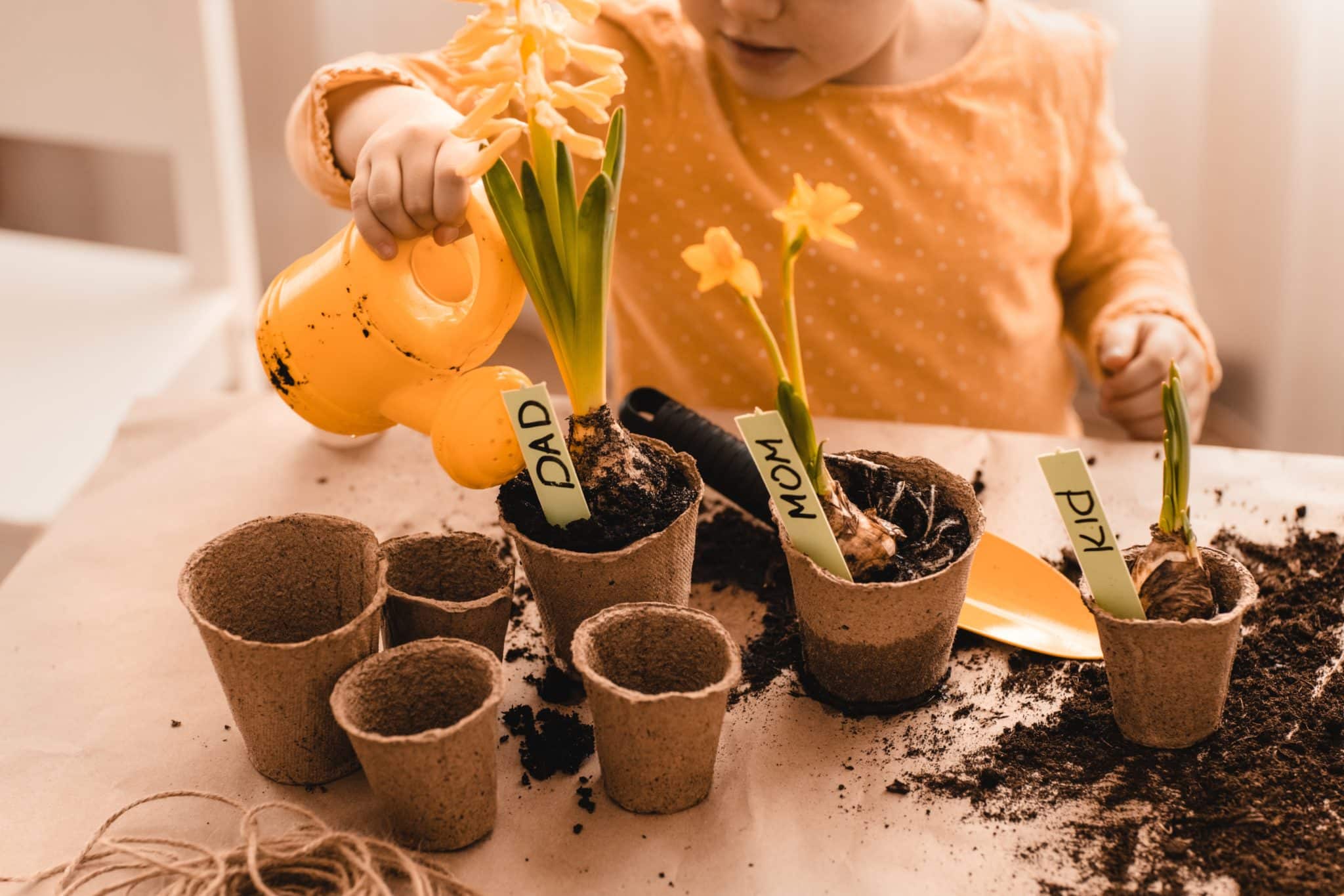 Vie pratique montessori enfant qui fait du jardinage en arrosant des pot