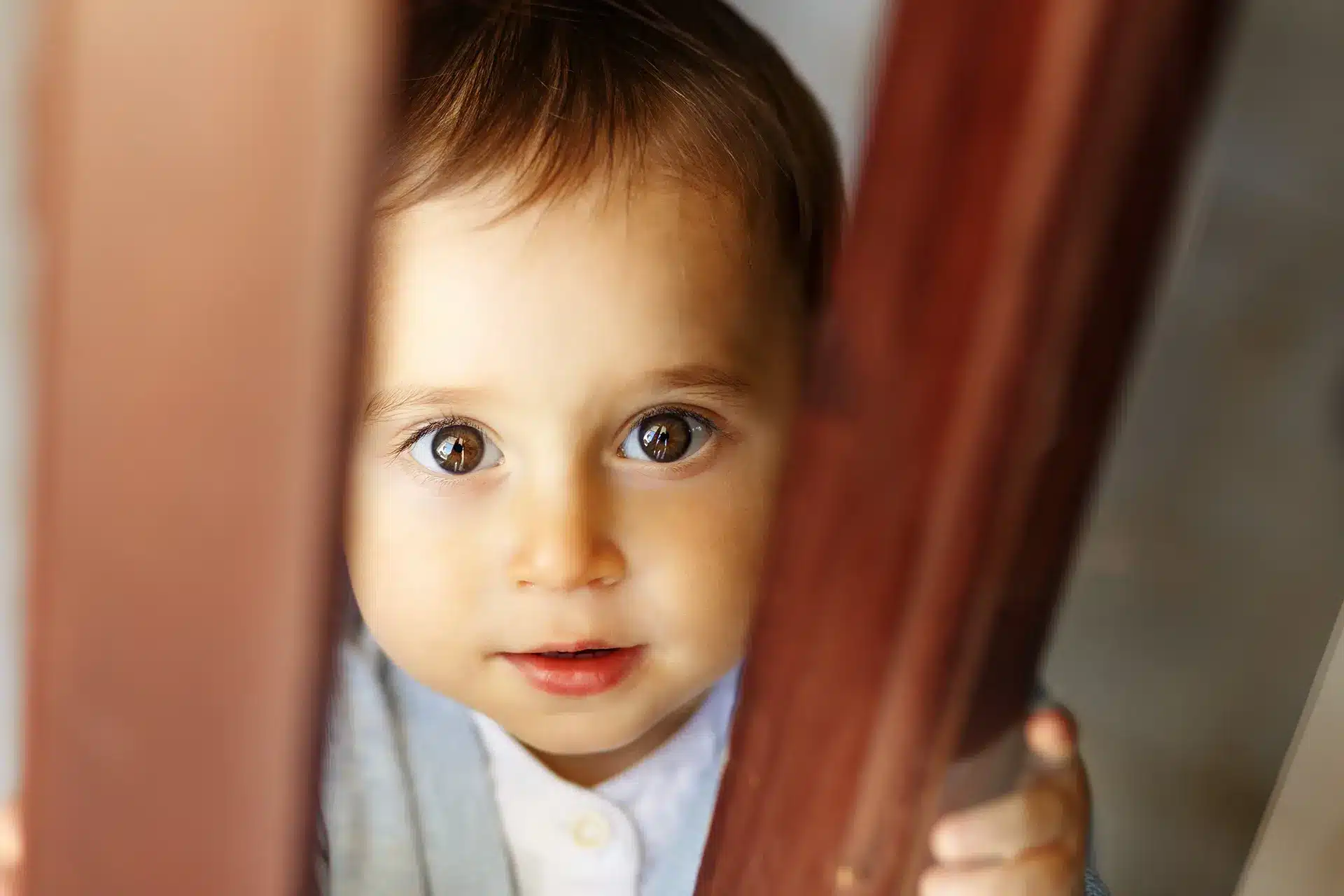 Un bébé qui sort d'une porte en bois est présenté dans le guide ultime des jouets Montessori pour les enfants de 1 an.
