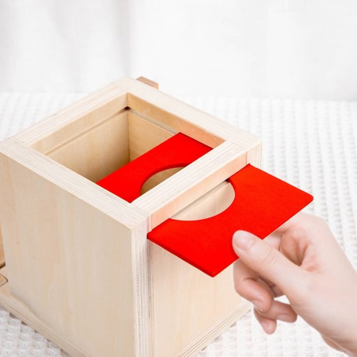 Eine Person legt ein rotes Blatt Papier in die 4-in-1-Permanenzbox.