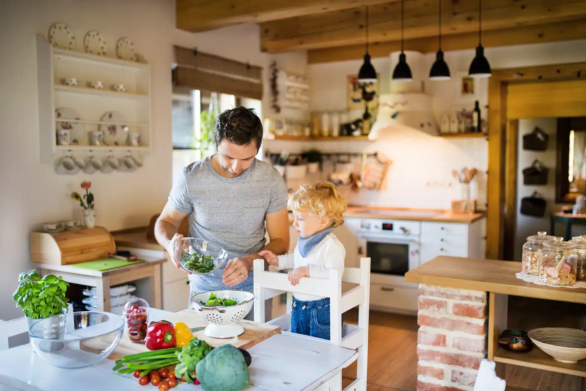 Ein Mann und ein Kind, die in einer Montessori-Küche eine Bildungserfahrung machen.