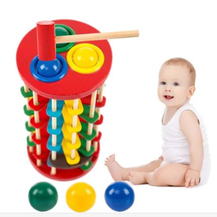 Ein Baby spielt mit einem Turm mit drei Hammerkugeln.