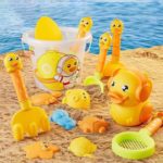 Sandspielzeug mit Enten und Eimern auf dem Sand.