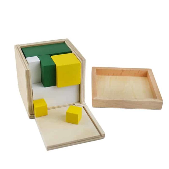 Une boîte en bois avec le Cube d'Apprentissage des Volumes à l'intérieur.