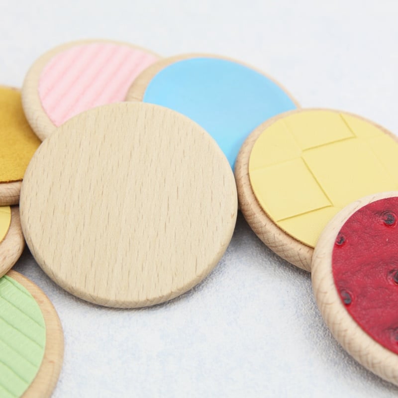 Un ensemble de Jouet de Pads Sensoriel en bois avec des formes colorées différentes.