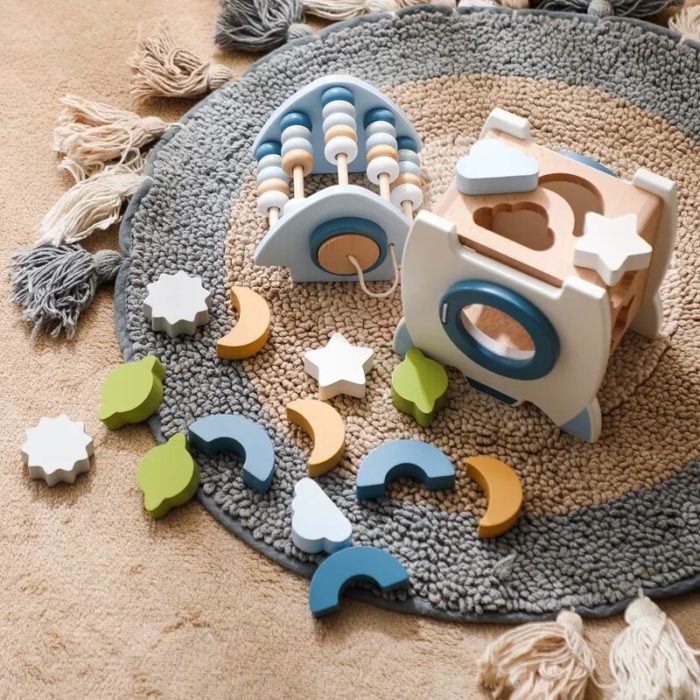A wooden toy with stars and moons on a carpet.