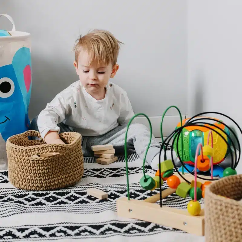 Ein Kind spielt in einem Spielzimmer mit Spielzeug.