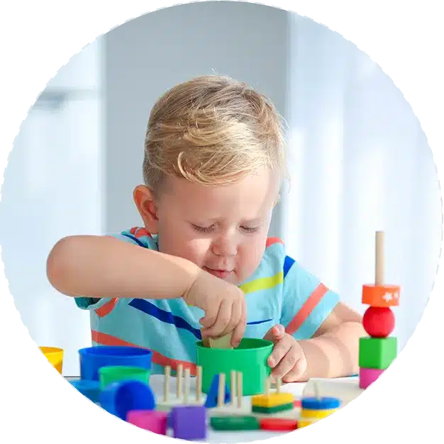 A young boy playing with colorful wooden blocks in his new home.