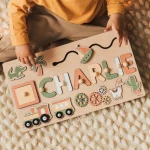 A child plays with a wooden board bearing the name Charlie.