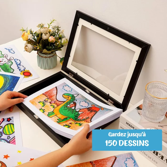 Une main d'enfant présente un dessin coloré de dinosaure de taille A4 dans un Cadre pour dessins d'enfants - stockez et exposez 150 dessins - taille A4 avec le texte "gardez jusqu'à 150 dessins".
