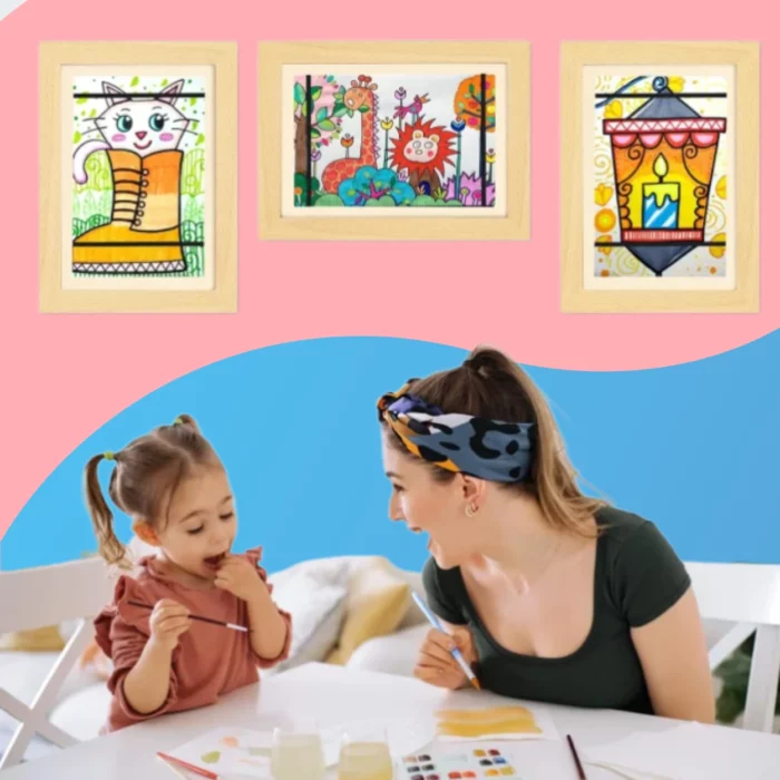 Une femme et une fillette peignent à une table, tandis que trois dessins colorés sont exposés derrière elles dans un Cadre pour dessins d'enfant, qui peut stocker et présenter jusqu'à 150 œuvres d'art au format A4.
