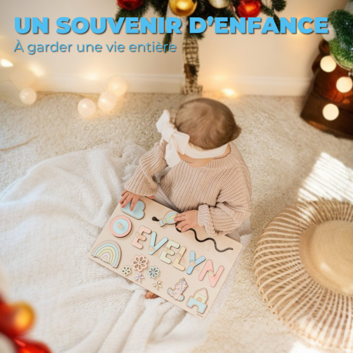 Un bébé est assis sur un tapis et tient un puzzle magnifiquement conçu. Personnalisé Prénom en Bois - Un souvenir unique avec le nom "Evelyn" et des illustrations colorées, entouré de décorations des Fêtes. Le texte en haut indique « Un souvenir d'enfance à garder une vie entière.