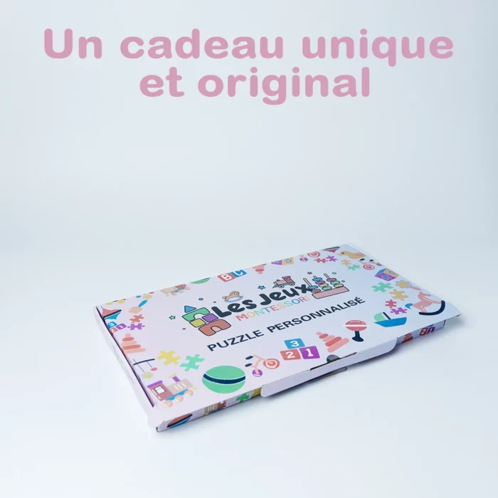 Une boîte à puzzle personnalisée avec des éléments de design colorés, avec « Puzzle Personnalisé Prénom en Bois », se dresse sur un fond blanc. Le texte rose au-dessus dit : « Un cadeau unique et original.