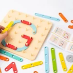 Main d'enfant jouant avec un tri de formes géométriques colorées et un puzzle "Jeu de construction Montessori à forme variable - Image à copier".