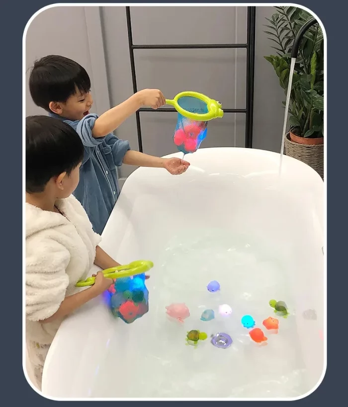 Deux enfants jouant avec le Jouet de Bain Lumineux pour la Baignoire dans une baignoire.