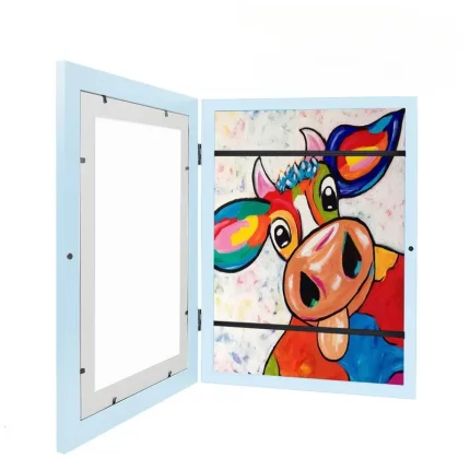 Une peinture colorée représentant une vache fantaisiste à l’intérieur d’un meuble blanc avec une porte ouverte.