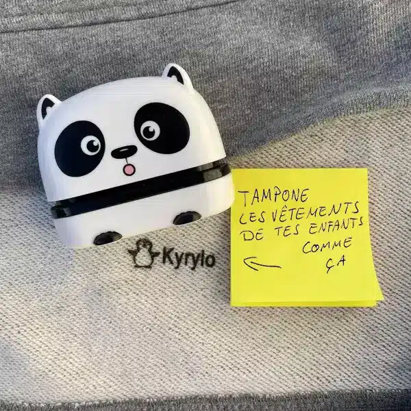 Un timbre de collection sur le thème du panda blanc repose sur un morceau de tissu gris sur lequel est écrit « Kyrylo ». Une note jaune à proximité indique « Tamponne les vêtements de tes enfants comme ça », avec une flèche pointant vers le timbre.