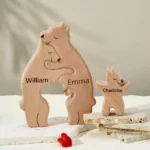 Les figurines Puzzle Personnalisé De Famille D'ours En Bois, mettant en vedette les personnages William, Emma et Charlotte, sont disposées sur une surface texturée avec un petit cœur rouge placé à proximité.