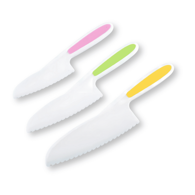 Le Coffret Couteaux Enfants - Set 3 Pièces comprend trois couteaux en plastique blanc avec des lames dentelées et des manches aux couleurs ludiques rose, vert et jaune, ce qui les rend idéaux pour enseigner aux enfants des techniques de coupe en toute sécurité.