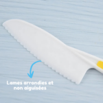 Le couteau en plastique blanc de la gamme « Couteaux Enfants - Set 3 Pièces » est doté d'un tranchant dentelé et d'une pointe arrondie. Étiqueté en français « Lames arrondies et non aiguisées », il garantit une utilisation sûre par les petites mains.