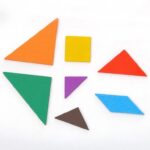 Le Petit Tangram Bois Couleurs Montessori présente sept formes géométriques colorées, dont un carré, des triangles, un parallélogramme et un trapèze, astucieusement disposés sur un fond blanc.