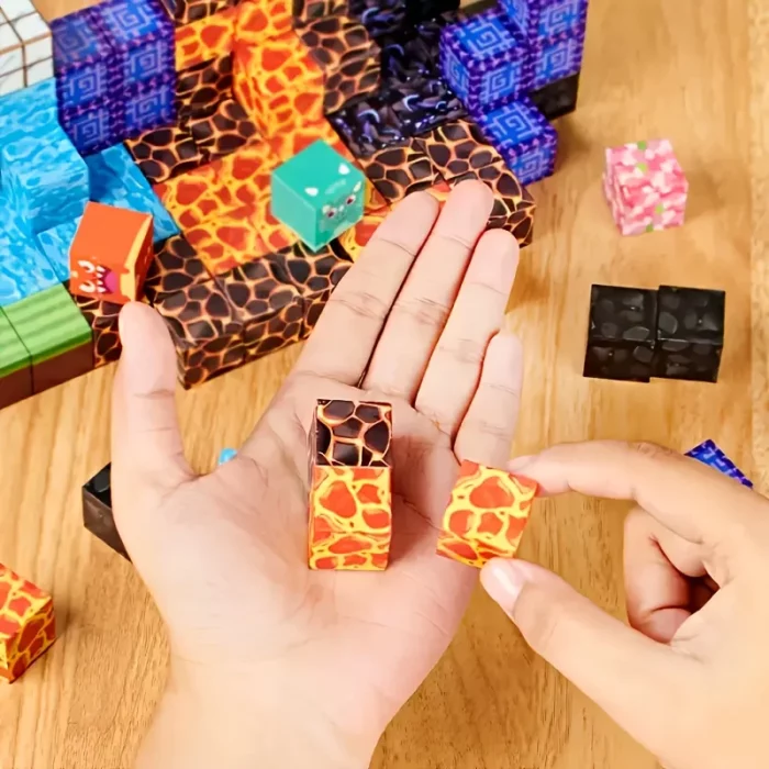 Quelqu'un dispose de petits blocs de mines à motifs de lave de « Mine Blocks - L'univers virtuel dans la vie réelle » sur une table en bois avec d'autres pièces colorées, fusionnant des thèmes virtuels avec la créativité de la vie réelle.